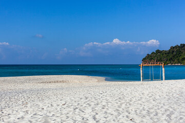 Fototapeta premium Koh Adang Beach, Thailand. White sand beach with turquoise ocean water. Swing on the shore with clear blue sky. Tropical paradise in Andaman Sea.