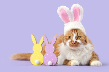 Cute cat in bunny ears and toy rabbits on lilac background. Easter celebration
