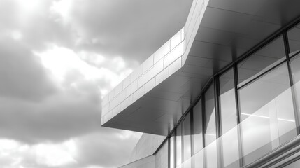 Fototapeta premium Modern Architectural Facade with Dramatic Cloudy Sky in Black and White Photograph