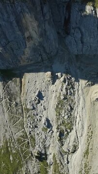 Vertical screen Steep Cliff With Talus And Erosion. Jagged Mountain Terrain With Erosion Patterns And Sparse Vegetation. Rocky Steep Slope With Talus Deposits And Zigzag Erosion Illustrating