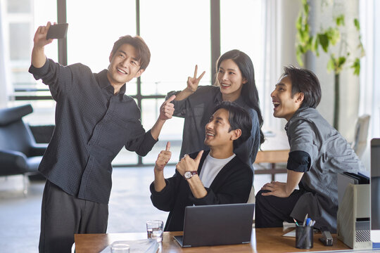 A group of cheerful office coworkers snapping a selfie