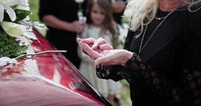 Funeral, hands and woman with ring in graveyard for memorial service, burial and goodbye for mourning. Family, grief and condolences at cemetery with remembrance, death and compassion or respect