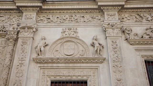 Ornate limestone facade in Seville shows NO8DO medallion, putti, floral friezes, Corinthian pilasters, and cornices as the camera pans slowly under soft daylight.