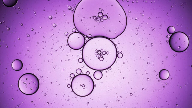 Vibrant purple oil droplets on water with reflective bubbles