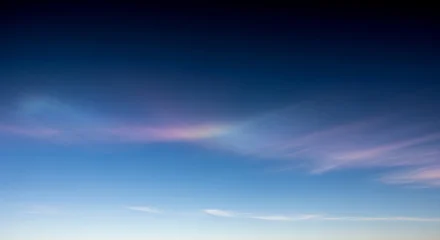 The serene blue sky with a few wispy clouds is transitioning to a peaceful evening atmosphere with hues of pink and purple. © Sky