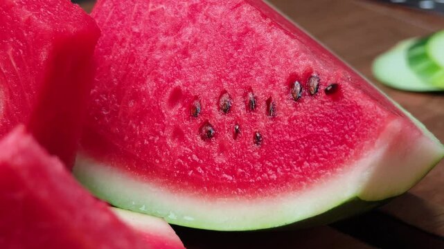 Fresh watermelon slices arranged on a wooden plate.