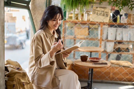 Young woman enjoys a quiet moment in a caf��, lost in the pages of a book