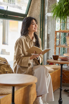 Young woman enjoys a quiet moment in a caf��, lost in the pages of a book