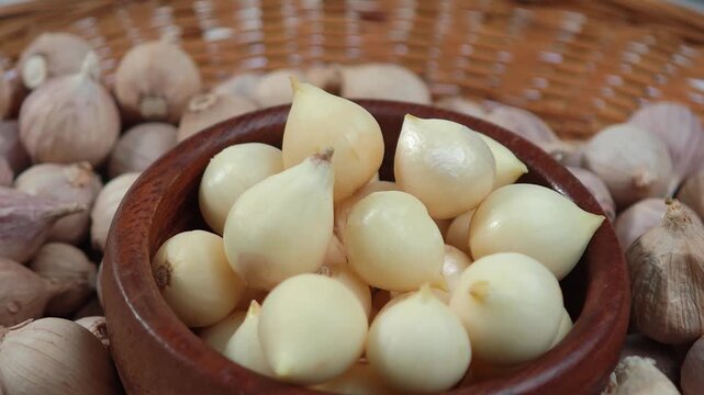 Single clove garlic herb in a wooden cup.