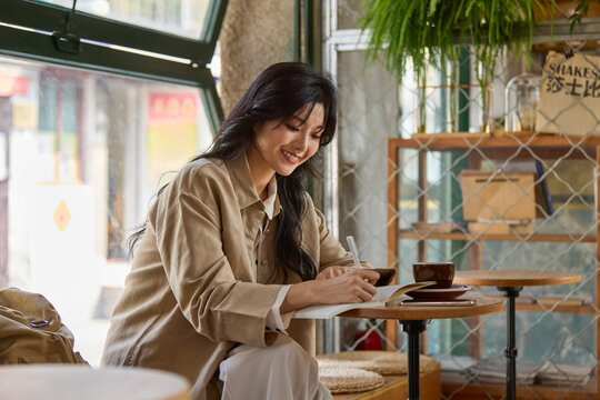 Young woman enjoys a quiet moment in a caf��, lost in the pages of a book