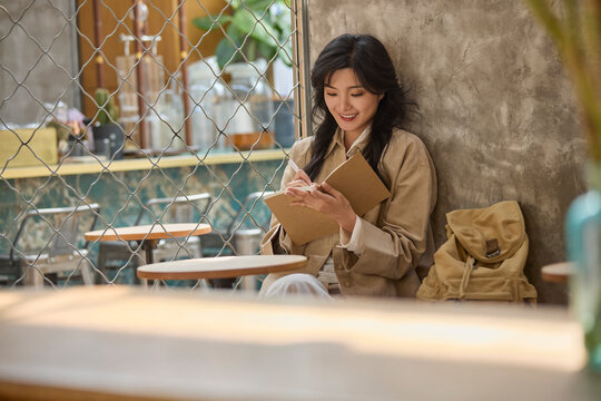 Young woman enjoys a quiet moment in a caf��, lost in the pages of a book