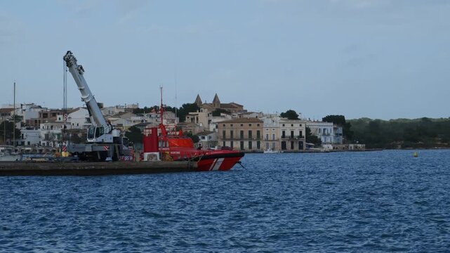 Maritime salvage vessel and crane in the port of Portocolom, Mallorca, Spain.