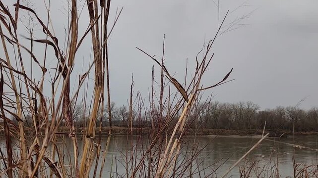 Lightning strike over river during thunderstorm with bolt near end of clip
