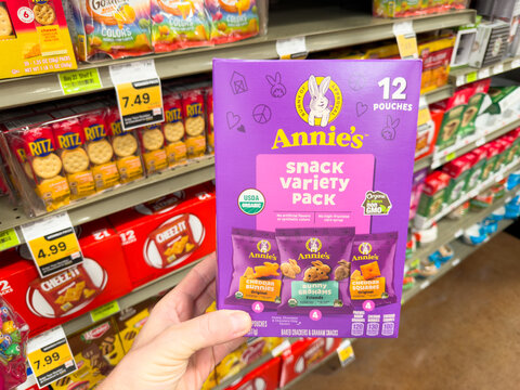 Annie&rsquo;s Snack Variety Pack Organic Kids Snacks Box Held In Hand In Grocery Store Aisle