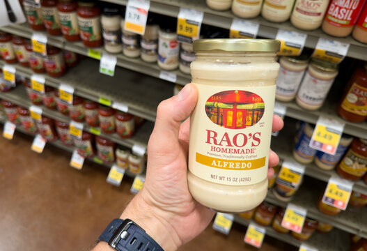 Rao&rsquo;s Homemade Alfredo Pasta Sauce Jar Held In Hand In Grocery Store Aisle