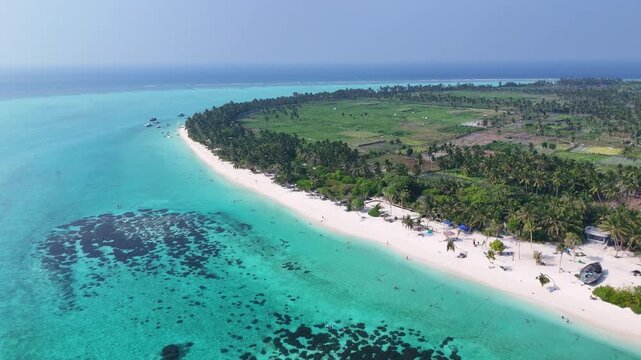 Stunning wide-angle drone view capturing the crystal-clear turquoise sea in the foreground with the tropical paradise of Thoddoo Island appearing on the horizon.