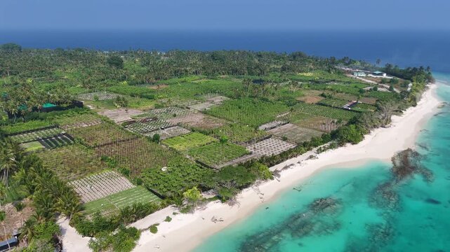 Spectacular aerial view of Thoddoo Island&rsquo;s square agricultural fields contrasting with the bright turquoise Indian Ocean in the background.