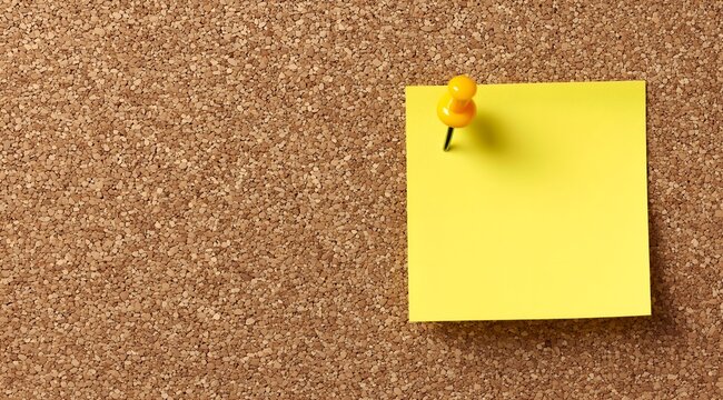 A yellow sticky note pinned to a corkboard, ideal for reminders and organization in an office or study environment.