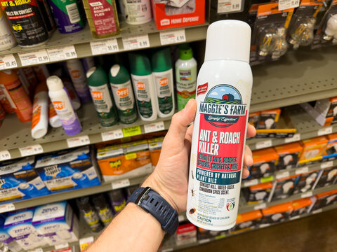 Maggie&rsquo;s Farm Ant And Roach Killer Spray Can Held In Hand In Hardware Store Pest Control Aisle