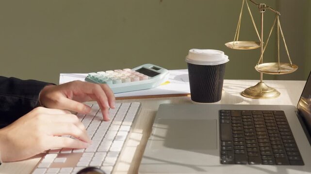 Judge gavel placed on desk near computer keyboard in law office. Legal consultation, justice system and professional law firm workplace concept.