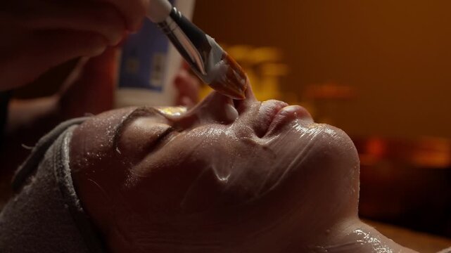 Close-up relaxing facial treatment with hydrating mask and serum application at spa, showcasing glowing skin care ritual and professional beauty therapy