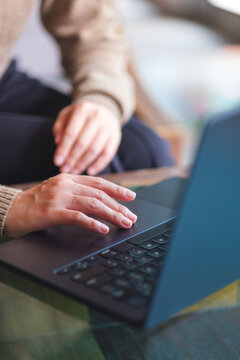 Vertical closeup image of a woman hand working and touching on laptop computer touchpad