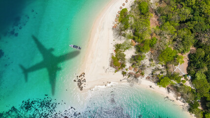 Aerial view of shadow passenger plane silhouette and sandy beach blue sea with waves at sea beach summer vacation sea travel concept	
