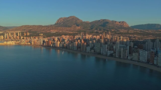 Breathtaking aerial footage capturing the benidorm cityscape and sandy beaches during a spectacular sunrise, highlighting the mediterranean coast