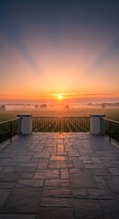 Fototapeta premium Beautiful sunrise view from a stone terrace overlooking a misty vineyard