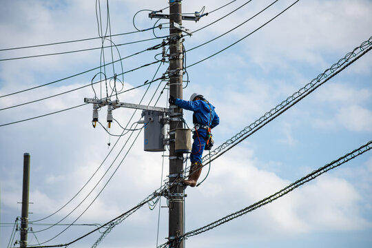 電柱の電気工事をする作業員