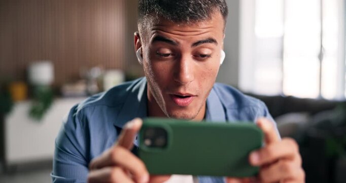 Man, phone and earphones for movie surprise on sofa with video, streaming subscription and online channel. Relax, person and tech in home for web entertainment, internet show or watching series