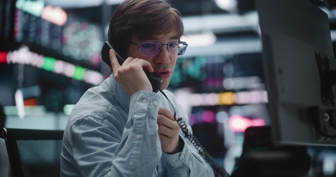 Professional Broker Taking Urgent Call on Landline Phone at Trading Desk. Man Coordinates Market Orders and Provides Real Time Consultation to Clients. Concept of Reliable Investment Consultation.