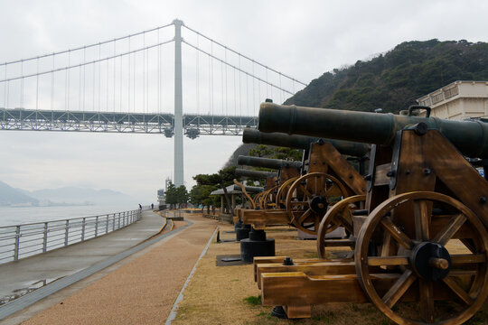 View of Choshu Cannon replicas and the Kanmon Bridge in Shimonoseki, Yamaguchi, Japan.
