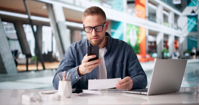 Man Meticulously Reviewing Payroll Checks