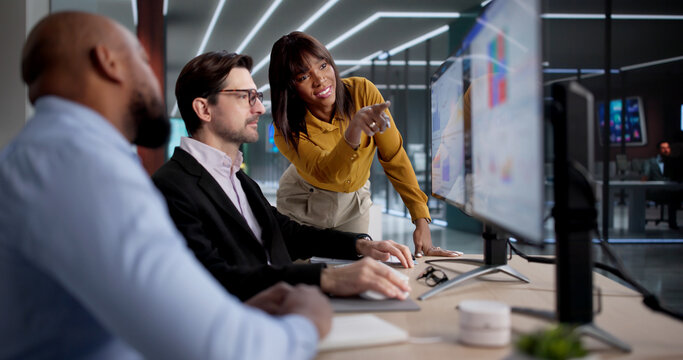 Diverse Team Using Computers To Analyze Data And Manage Business Performance