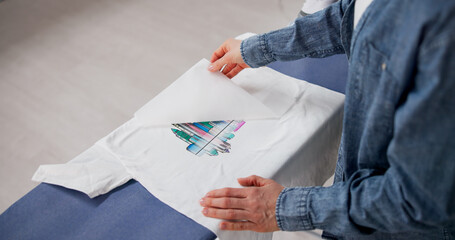 Woman Applying Custom Heat Transfer Design On T-Shirt With Iron