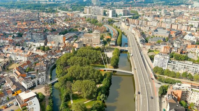Ghent, Belgium. Keizerpark - City park. Esco (Scheldt) river embankment. Panorama of the city from the air. Cloudy weather, summer day. Drone footage, Departure of the camera