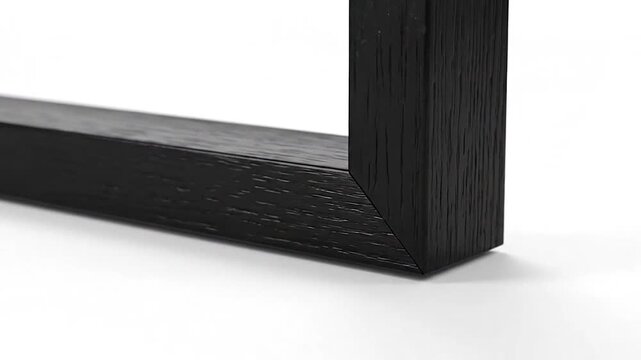 Close-up of a simple black wooden frame corner on a white background