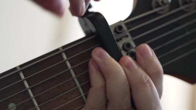 Capo Being Placed on Seven String Electric Guitar Neck