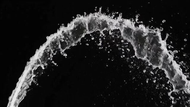 A dynamic stream of clear liquid splashes against a dark background