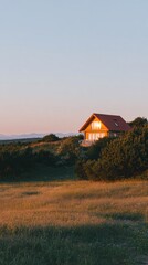 Modern terracotta villa house glowing warmly during sunset over natural meadow landscape for real estate marketing banner with copy space and golden hour lighting