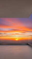 Fototapeta premium Modern balcony with glass railing overlooking a vibrant sunset sky