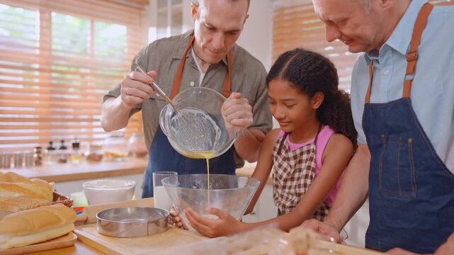 Caucasian senior gay couple baking bakery with adopted daughter in house. 