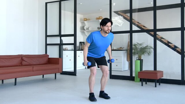 Determined active fit man practicing dumbbell triceps kickback exercise, strengthening and toning arm muscles while doing weight training workout at home.