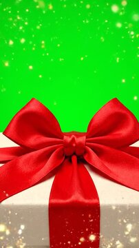 A festive gift box with a red ribbon bow on a green background