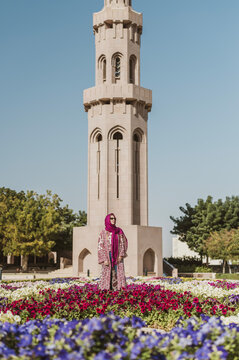 Caucasian woman wearing hijab in flowering courtyard of islamic mosque
