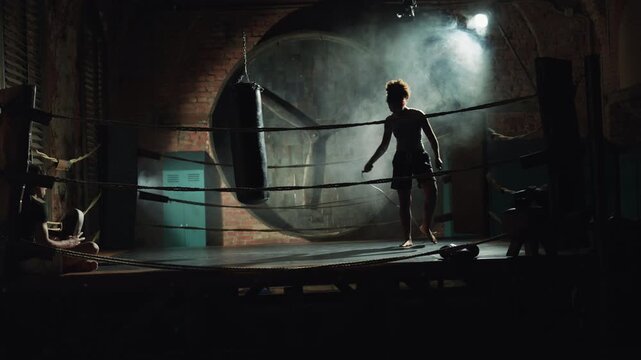 Motivated woman training in gym, skipping rope for lose weight and fat burning. African american sportswoman practicing physical exercises in fitness center or fight club, preparing to boxing fight