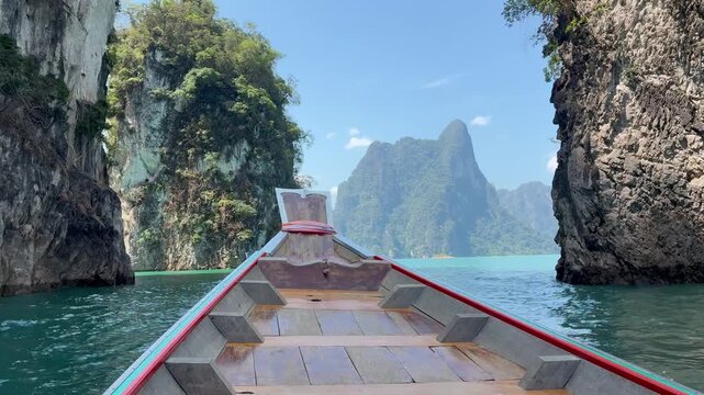 Bow of the boat moving through the beautiful limestone cliffs on the lake in Kao Sok National Park in Thailand