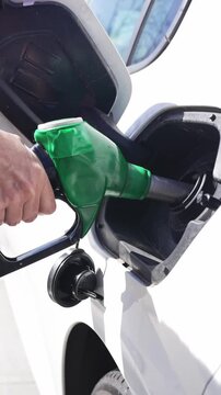 Hand pumping gasoline into car at gas station gas crisis, inflation