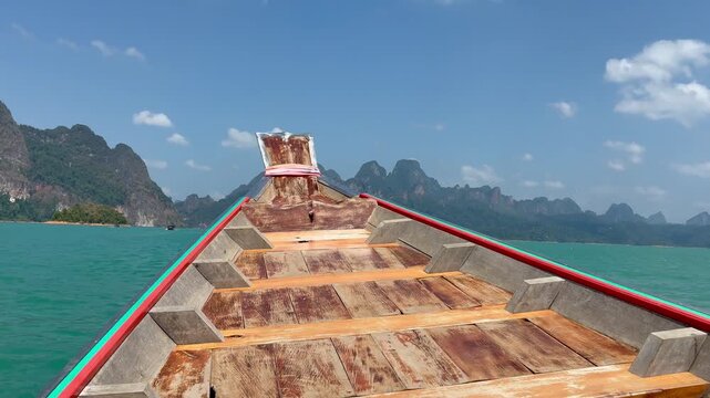 Bow of the boat moving through the beautiful limestone cliffs on the lake in Kao Sok National Park in Thailand